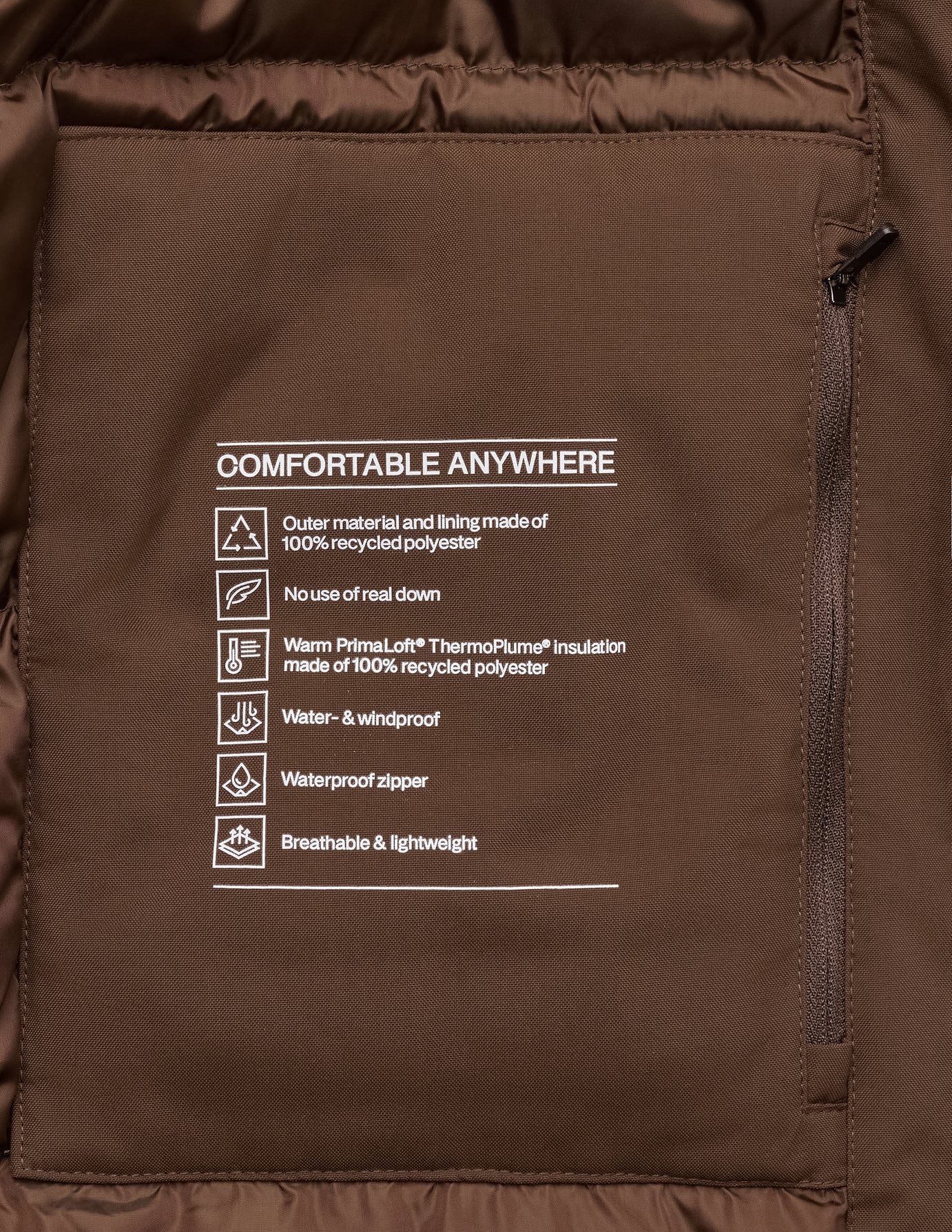 Innerficka på Utility Jacket Saddle Brown med text som beskriver återvunnen polyester, isolering och prestanda.